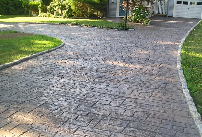 Stamped concrete driveway with concrete edging along both sides of driveway.