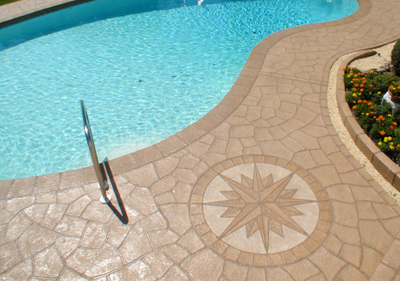 Custom stamped concrete pool surround with compass stamped into concrete. 